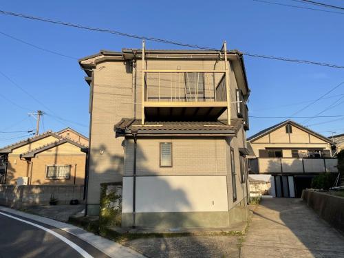 un edificio con balcón en el lateral de una calle en IKI HOUSE KATSUMOTOURA - Vacation STAY 13495v, en Iki