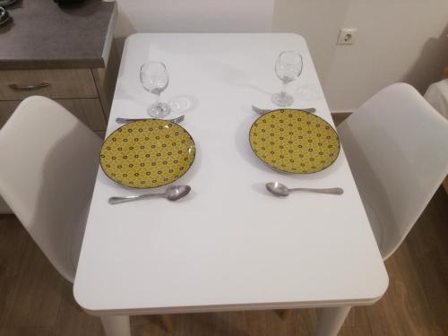 a white table with two glasses and two chairs at CENTRAL ELEVEN in Agios Kirykos