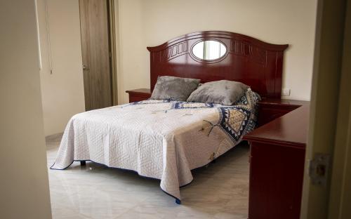 - une chambre avec un lit doté d'une tête de lit en bois dans l'établissement linda vista, à El Castillo