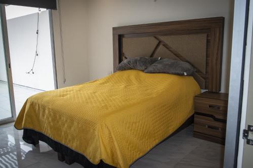 - une chambre avec un lit jaune et 2 oreillers dans l'établissement linda vista, à El Castillo