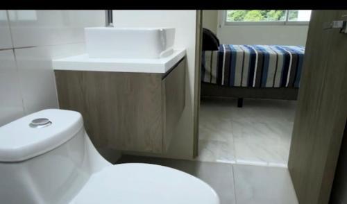 La salle de bains est pourvue de toilettes blanches et d'un lavabo. dans l'établissement linda vista, à El Castillo
