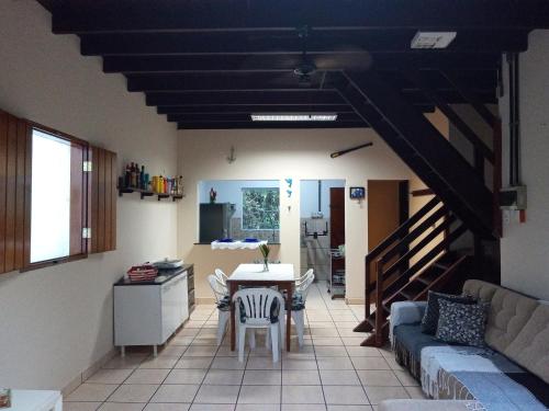 eine Küche und ein Wohnzimmer mit einem Tisch und einem Sofa in der Unterkunft Chalé Da Bia in Cananéia