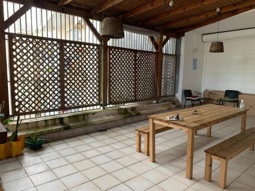 ポワンタピートルにあるRETE ZEN GUESTHOUSEの木製テーブルとベンチ付きの広い客室です。