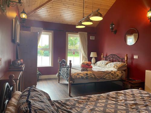 a bedroom with two beds and red walls at Kingstown House in Cashel