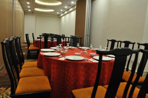 a long table with a red table cloth and chairs at Grand Riverview Hotel in Kota Bharu