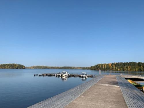 un muelle con barcos atracados en un lago en Viihtyisä lomahuoneisto Sastamalan Ellivuoressa, en Sastamala