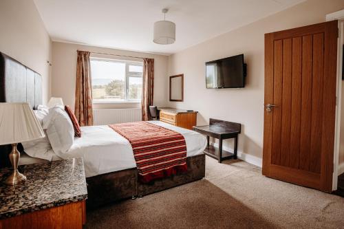 una camera d'albergo con letto e TV di Mountain View Lodge a Newcastle