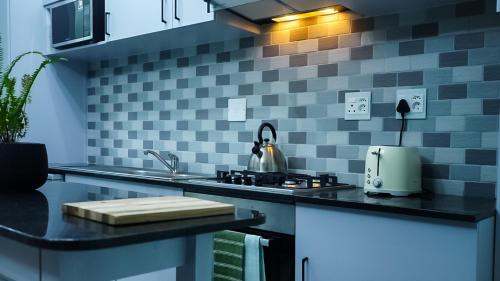 a kitchen with a sink and a stove at 1-bedroom apartment with secure basement parking in Stellenbosch