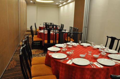 a table with a red table cloth on it with chairs at Grand Riverview Hotel in Kota Bharu