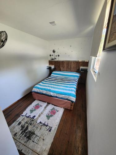Dormitorio pequeño con cama y alfombra en Casa Conteiner en Salta