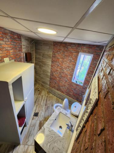 a bathroom with a sink and a toilet in a room at Casa Conteiner in Salta