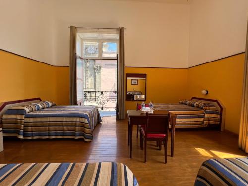 een kamer met 2 bedden, een tafel en een raam bij Hotel Isabel in Mexico-Stad