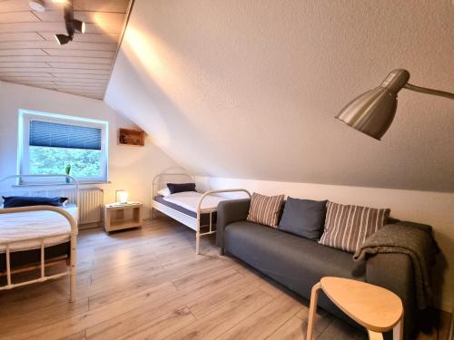 ein Wohnzimmer mit einem Sofa und einem Bett in der Unterkunft Ferienwohnung Wipperau I in Uelzen