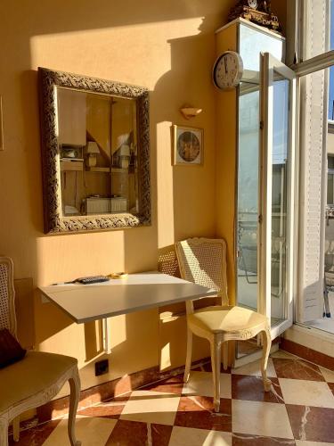 - une table et des chaises dans une pièce avec un miroir dans l'établissement Home Sweet Home Claridge Champs-Elysées, à Paris