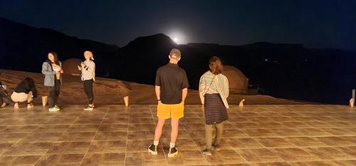 a group of people standing in front of a tent at Hasan Zawaideh luxury camp 2 in Wadi Rum