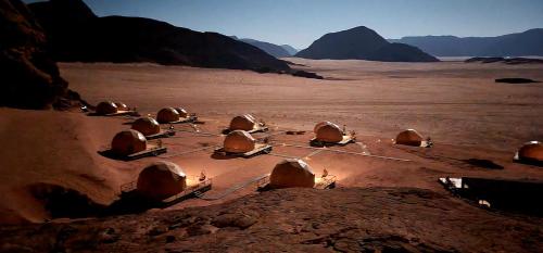 a group of clay domes sitting in the desert at Hasan Zawaideh luxury camp 2 in Wadi Rum
