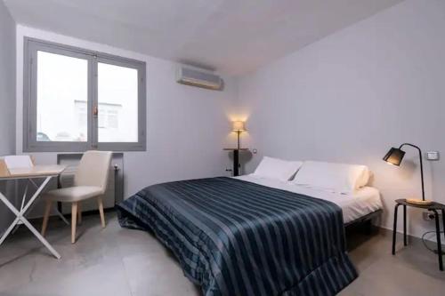 een slaapkamer met een bed, een bureau en een raam bij Dolce Vita in La Marsa