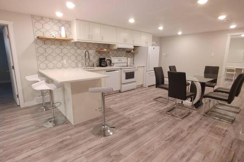 a kitchen and living room with a table and chairs at Beautiful 2 bedroom + office basement suite in Calgary