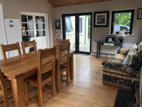 sala de estar con mesa de madera y sofá en Skellig View en Portmagee