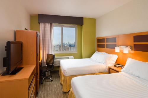 um quarto de hotel com duas camas e uma televisão em Holiday Inn Express - Times Square, an IHG Hotel em Nova York