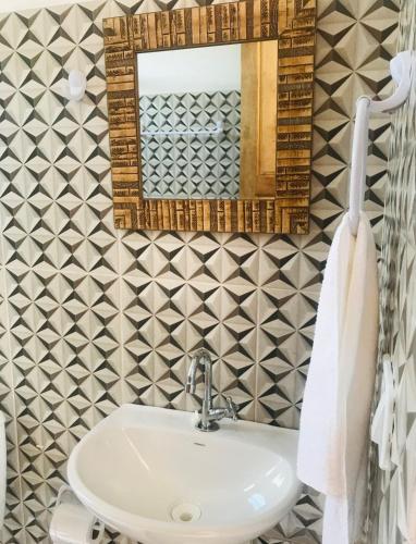 a bathroom with a sink and a mirror at Natal Chalés Nova Caraiva in Caraíva