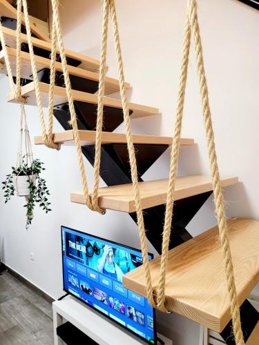 a room with a tv and rope shelves at Casinha da Esquina in Amieira