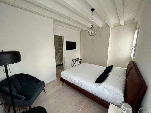 - une chambre avec un lit blanc et une chaise dans l'établissement Alla Torre 735 - Stay Local Burano, à Burano