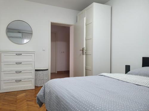 um quarto branco com uma cama e um espelho em Golden day em Vinkovci