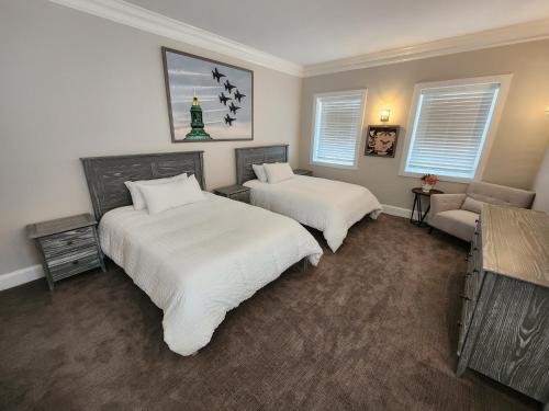 a bedroom with two beds and a couch and windows at Capital Hotel Annapolis in Annapolis