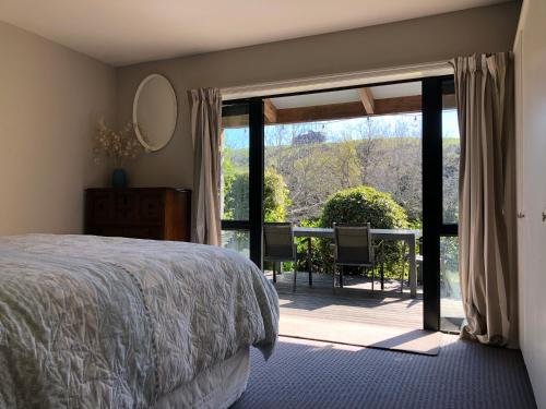 a bedroom with a bed and a table with a view at Tranquil Family Retreat in Akaroa