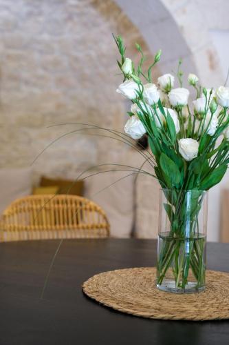 a vase of white flowers sitting on a table at Trullo Natù - private villa in Alberobello