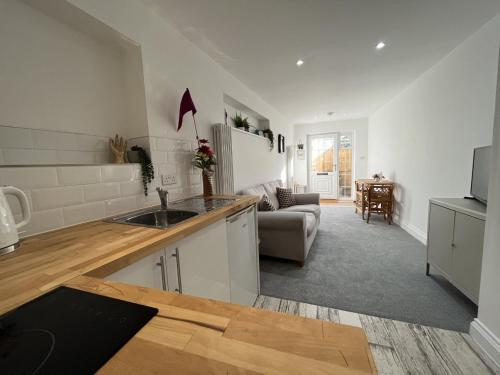 a kitchen with a sink and a living room at St Annex, Boutique Holiday Apartment for 2 people in Torquay - with Private HOT TUB! in Torquay