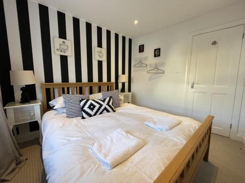a bedroom with a large bed with black and white stripes at St Annex, Boutique Holiday Apartment for 2 people in Torquay - with Private HOT TUB! in Torquay