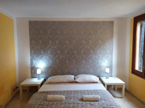 ein Schlafzimmer mit einem großen Bett mit zwei Nachttischen und zwei Tischen in der Unterkunft Two steps from Rialto bridge in Venedig