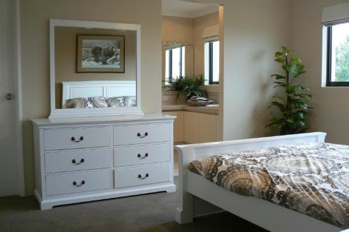 a bedroom with a white dresser and a bed at Le Boulevard in Mindarie