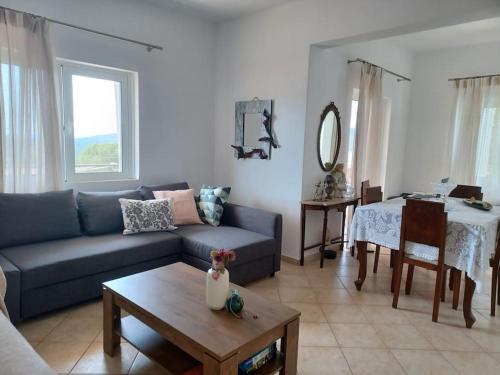 Modern vacation house near Ermioni في Loukaḯtion: غرفة معيشة مع أريكة زرقاء وطاولة