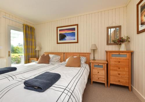 a bedroom with two twin beds and a mirror at Gwêl y Môr in Abersoch