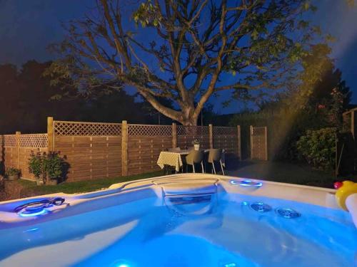 a hot tub in a backyard with a table and chairs at The Nookery in Winscombe