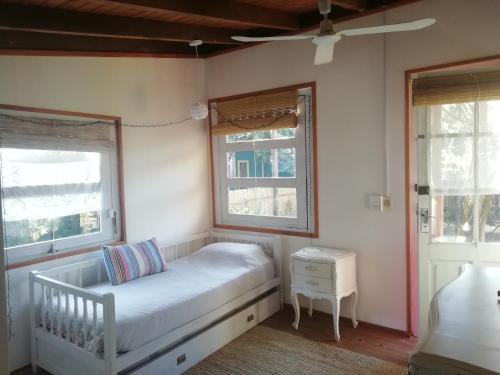 1 dormitorio pequeño con 1 cama y 2 ventanas en Casa La Juanita, en José Ignacio