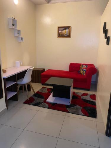 a living room with a red couch and a table at Posh Hotel and Suites Victoria Island in Lagos