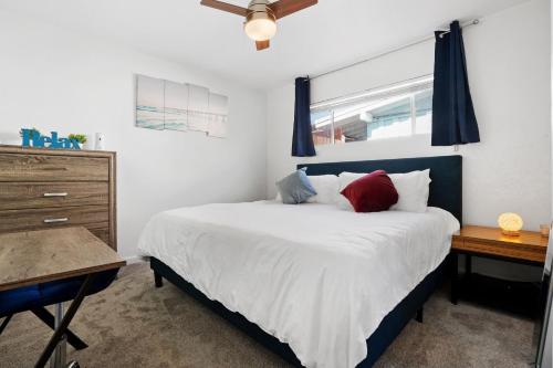 - une chambre avec un lit doté d'oreillers rouges et bleus dans l'établissement The Green Haven, 1 Minute Walk to the Beach and Restaurants, King Beds, Beach Amenities, à Ventura