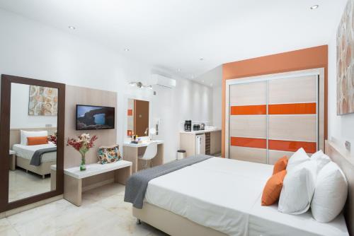 a bedroom with a large bed and a bathroom at Loutsiana Deluxe Apts in Ayia Napa