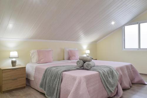 two beds in a room with pink sheets and pillows at Casa da Praia, a Home in Madeira in Ribeira Brava