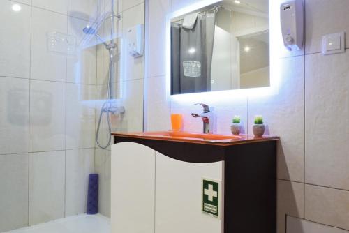 a bathroom with a sink and a shower with a mirror at Casa da Praia, a Home in Madeira in Ribeira Brava