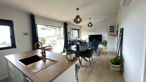 a kitchen and living room with a sink and a table at Paihia Central Apartments in Paihia