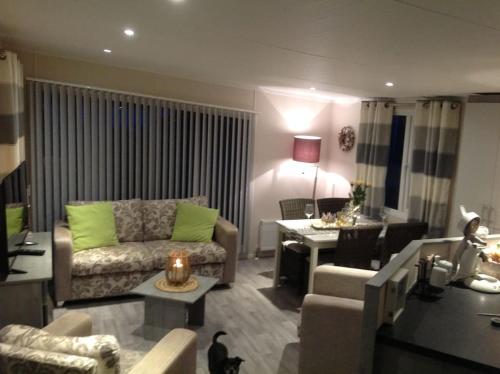 a living room with a couch and a table at Luxus Chalet im schönen Recratiepark De Veerstal in Rheden