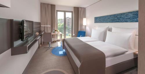 ein Hotelzimmer mit einem Bett und einem Flachbild-TV in der Unterkunft Dorint Hotel Hamburg-Eppendorf in Hamburg