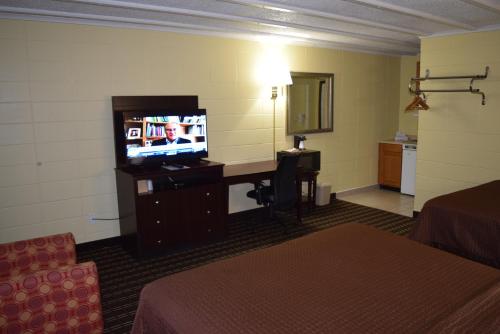a hotel room with a television and a desk in a room at White Oaks Motel Pennsville/Carneys Point in Pennsville