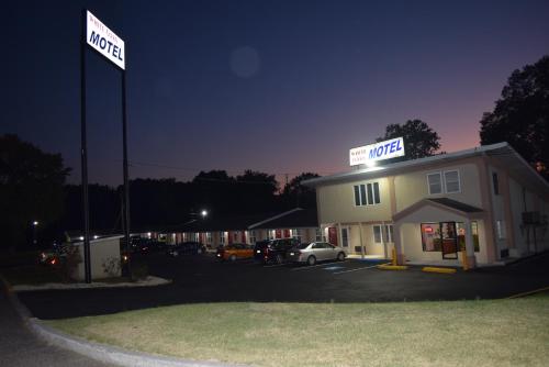 a hotel with cars parked in a parking lot at night at White Oaks Motel Pennsville/Carneys Point in Pennsville
