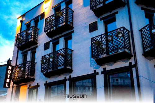 a white building with black balconies and windows at Museum Hotel in Pristina